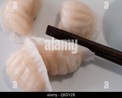 Dim Sum oder Har Gow Shrimp Dumpling mit Essstäbchen, auch als ha-Gow, Heukau oder Hakao anglizisiert Stockfoto