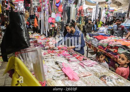 Palästinenser kaufen auf einem lokalen Markt ein, bevor die Eid al-Fitr-Feierlichkeiten stattfinden, die das Ende des heiligen muslimischen Fastenmonats Ramadan feiern. Stockfoto