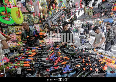 Palästinenser kaufen auf einem lokalen Markt ein, bevor die Eid al-Fitr-Feierlichkeiten stattfinden, die das Ende des heiligen muslimischen Fastenmonats Ramadan feiern. Stockfoto