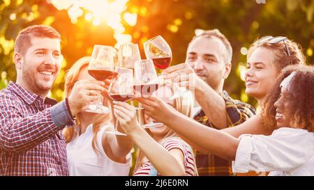 Trendige Freunde trinken und toasten Rotwein bei der Restaurantparty Stockfoto