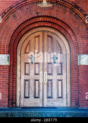 Hintergrund einer schönen gewölbten Holztüren mit eingedeckten Kreuzfenstern. Stockfoto