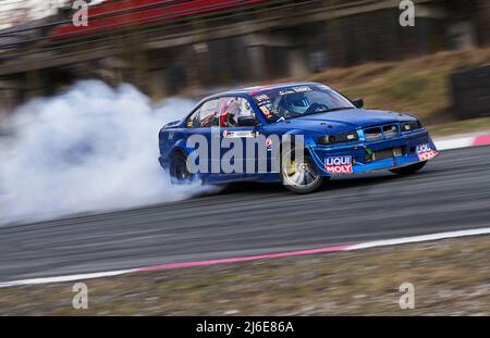 10-04-2022 Riga, Lettland Sportwagenraddriften. Verschwommenes Bild Diffusion Rennen Drift Auto mit viel Rauch von brennenden Reifen auf der Rennstrecke. Spor Stockfoto