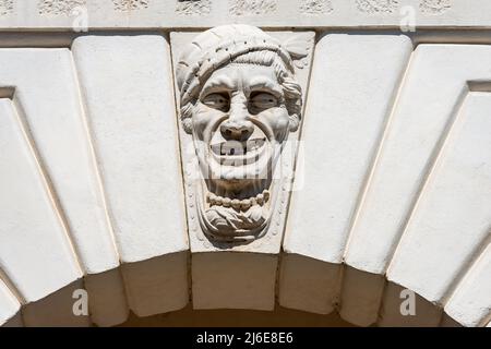 Brescia. Mittelalterlicher Palast von Broletto (Palazzo Broletto oder Palazzo del Governo). Bogen mit Keystone und einer grotesken Maske. Lombardei, Italien. Stockfoto