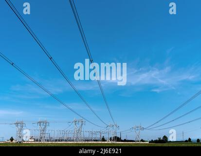 Hochspannungsleitungen, Hochspannungs-elektrische Übertragungstürme am blauen Himmel, Kopierraum Stockfoto