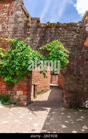 Zum Kulturerbe gehört die Porte Plate, die benannt ist, weil sie keinen Turm hat. Es war der Haupteingang zum alten Priorium von Collonges-la-Rouge Stockfoto