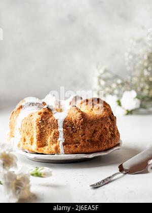 Schöne flauschige gebündelt Kuchen mit Glasur verziert. Stillleben mit Leinenserviette und Blumen Stockfoto