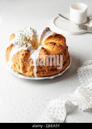 Schöne flauschige gebündelt Kuchen mit Glasur und Blumen verziert. Komposition in hoher Tonart. Ostern orthodox süßes Brot mit Blumen Stockfoto