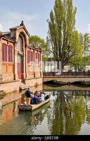 Colmar, Frankreich - April 2022: Touristen in einem kleinen Boot auf dem Kanal, der durch die Stadt läuft Stockfoto