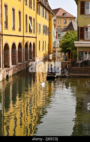 Colmar, Frankreich - April 2022: Touristen steigen in ein kleines Boot für eine Fahrt in einem kleinen Boot auf dem Kanal, der durch die Stadt läuft Stockfoto