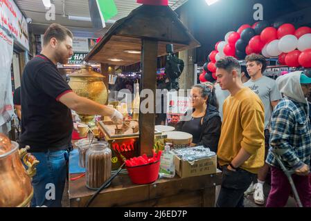 30. April, Lakemba, Sydney, Australien: In der letzten Nacht des Ramadan in Sydney ist das Ramadan Nights Festival von Sonnenuntergang um 17,30 Uhr bis zum 02,00. Am nächsten Morgen in vollem Gange. Hier macht ein Mann heißen Sandkaffee für einen wartenden Kunden. Lange Menschenschlangen die Straße entlang, die darauf warten, dieses und andere Lebensmittel aus den vielen Nationen zu kaufen, die jeden Abend während des Festivals auf diesem Markt vertreten sind. Stockfoto