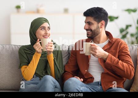 Glückliches Nahöstliches Paar, Das Zu Hause Kaffee Hält Stockfoto
