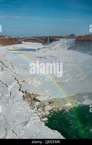 Regenbogen über den Niagarafällen im Winter mit viel Eis und Schnee Stockfoto