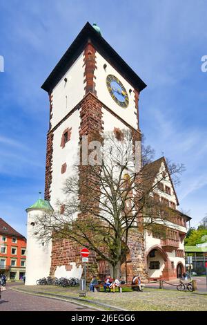 Freiburg, Deutschland - April 2022: Turm mit Tor namens Schwabentor, ein verbliebenes Stadttor der mittelalterlichen Verteidigungsmauer Stockfoto