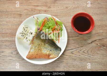 Gegrillter Lachsfisch mit japanischem Reis, Sesam und Salat auf dem Teller mit süßer Sojasauce Stockfoto