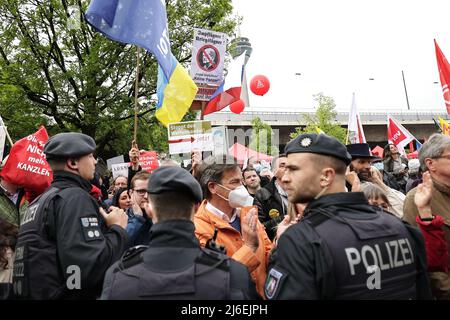 01. Mai 2022, Nordrhein-Westfalen, Düsseldorf: Menschen nehmen an der 1. Mai-Kundgebung des Deutschen Gewerkschaftsbundes (DGB) zum Tag der Arbeit Teil und stehen Polizisten gegenüber. Foto: David Young/dpa Stockfoto