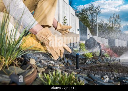 Automatische Installation und Einstellung von Gartenrasen im Garten durch einen professionellen Gartentechniker. Nahaufnahme Des Fotos. Stockfoto