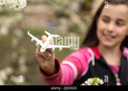 Kleines Mädchen mit einem Spielzeug Flugzeug im Garten Stockfoto