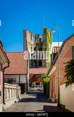 Straße in Visby mit Turmruinen im Hintergrund. Stockfoto