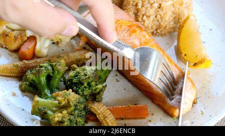 Gegrilltes Lachsfilet mit gemischtem Gemüse, Zitrone und Reis. Gesundes Mittagessen Stockfoto