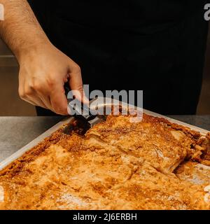 Küchenchef mit einer heißen Lasagne frisch gebacken, nur aus dem Ofen, Restaurant Küchenkonzept Stockfoto