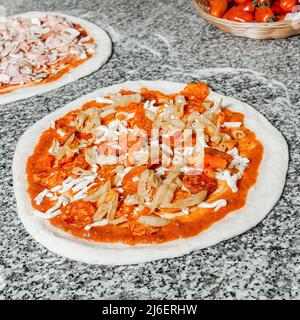 Teig und Zutaten für Pizza mit Tomaten, Schinken und Käse, fertig zum Backen, Restaurantkonzept Stockfoto