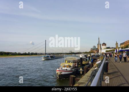 Rheinufer mit Promenade in Düsseldorf an einem sonnigen Tag mit blauem Himmel. Stockfoto