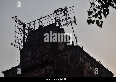 1. Mai 2022, Rajpur Sonarpur, Westbengalen, Indien: Indische Arbeiter arbeiten daran, am Internationalen Arbeitertag 2022 eine Plakatwand-Struktur auf einem Gebäude in Kalkutta zu befestigen. (Bild: © Sankhadeep Banerjee/ZUMA Press Wire) Stockfoto