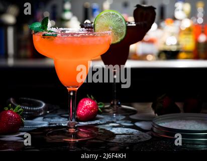 Eine glühende Erdbeere margarita garniert mit Limette, Minze und Erdbeeren. Stockfoto