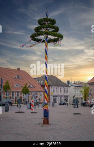 Ein bunt dekorierter Maibaum steht auf einem Marktplatz Stockfoto