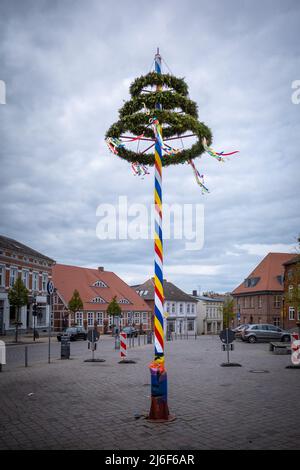 Ein bunt dekorierter Maibaum steht auf einem Marktplatz Stockfoto