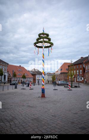 Ein bunt dekorierter Maibaum steht auf einem Marktplatz Stockfoto