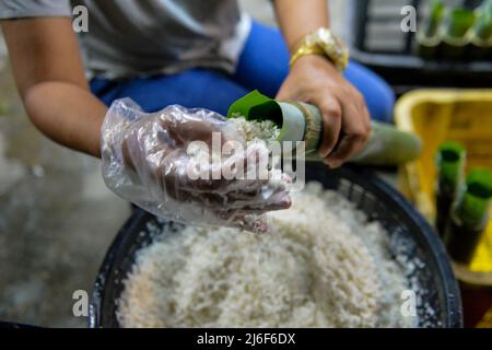 1. Mai 2022: Eine Frau bereitet "Lemang" zu, ein traditionelles Essen aus klejeweiligem Reis und Kokosnuss, das vor der Eid-al-Fitr-Feier in Seremban, Negeri Sembilan, Malaysia, in einem ausgehöhlten Bambusrohr gekocht wird. (Bild: © Fuad Nizam/ZUMA Press Wire) Stockfoto