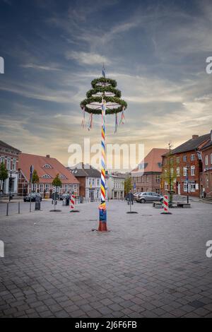 Ein bunt dekorierter Maibaum steht auf einem Marktplatz Stockfoto