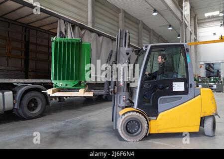 (220501) -- BUDAPEST, 1. Mai 2022 (Xinhua) -- Ein Arbeiter entlädt am 12. April 2022 im Csepel Freeport Logistics Park in Budapest, Ungarn, Waren von einem Lastwagen mit einem Gabelstapler. MIT „Budapests bedeutendem Logistikzentrum fördert die Zusammenarbeit zwischen China und der EU“ (Foto: Attila Volgyi/Xinhua) Stockfoto