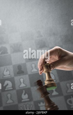 Ein Spieler checkmatet den König während eines Schachspiels: Strategiespiele und Turnierkonzept, Schachdiagramm im Hintergrund Stockfoto