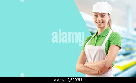 Junge weibliche Lebensmittelläden-Assistentin mit gekreuzten Armen, lächelt sie an der Kamera, leerer Kopierraum Stockfoto