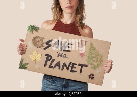 Frau mit einem Karton mit einer Aufschrift: Rette den Planeten. Stockfoto