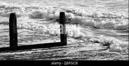 Raues Meer und verfallene Groynes am Strand von Teignmouth, South Devon. Stockfoto