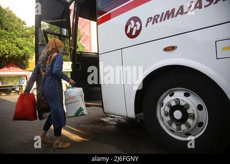 Passagiere, die zu ihren Heimatorte zurückkehren, steigen am Hauptbusbahnhof von Bekasi City, West Java, Indonesien, in einen Bus ein. Heimkrautler, die am Busbahnhof ankommen, sind vor der D-1 Eid al-Fitr 2022 recht ruhig. Die Heimreise der Eid im Jahr 2022 wird erneut durchgeführt. Präsident Joko Widodo (Jokowi) hat der indonesischen Bevölkerung erlaubt, 2022 inmitten der Covid-19-Pandemie nach Eid zu gehen. Die diesjährige Eid-Heimkehr-Tradition ist die erste Heimkehr indonesischer Staatsbürger, nachdem die vergangenen 2 Jahre aufgrund der hohen Anzahl von Covid-19-Fällen verboten wurden Stockfoto