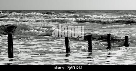 Raues Meer und verfallene Groynes am Strand von Teignmouth, South Devon. Stockfoto