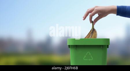 Frau, die biologisch abbaubaren organischen Abfall in einen Papierkorb legt, separates Abfallsammelungs- und Recyclingkonzept Stockfoto