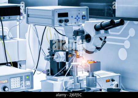 Chip-Testgeräte. Herstellung von Mikrochips. Eine Nahaufnahme einer Testprobe eines Transistorchips unter einem Mikroskop im Labor. Automatisch Stockfoto