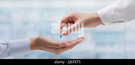 Professioneller Arzt, der einem Patienten ein verschreibungspflichtiges Medikament gibt Stockfoto