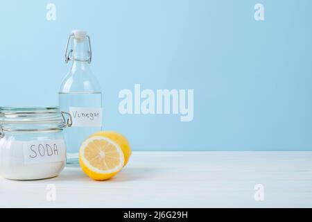 Backpulver im Glas, Essig, Zitrone geschnitten, auf einem blauen Hintergrund. Das Konzept der organischen Entfernung von Flecken auf Kleidung. Hochwertige Fotos Stockfoto