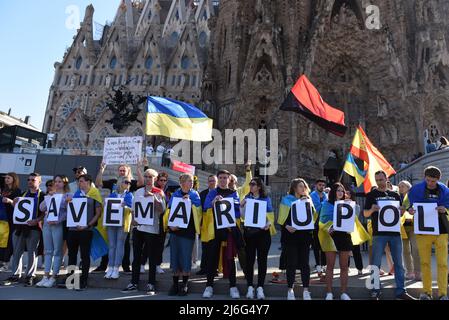 Während einer Demonstration gegen die russische Invasion in der Ukraine halten Demonstranten Flaggen und Plakate mit der Aufschrift „Save Mariupol“. Rund dreihundert Demonstranten, überwiegend Ukrainer, versammelten sich vor der berühmten Basilika Sagrada Familia in Barcelona, um einen grünen Korridor in Mariupol und Frieden für ihr Land zu fordern. Stockfoto