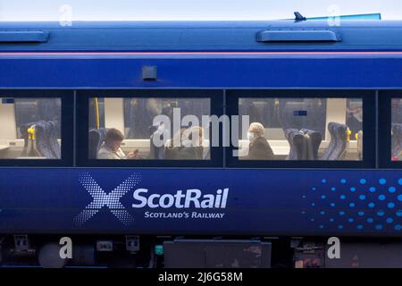 Bahnreisende von ScotRail in einem Zug der Klasse 170 mit dem Scotrail-Logo trägt einer der Passagiere eine Gesichtsmaske Stockfoto