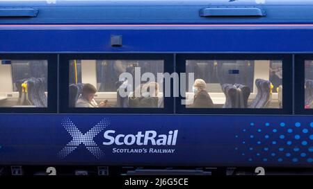 Bahnreisende von ScotRail in einem Zug der Klasse 170 mit dem Scotrail-Logo trägt einer der Passagiere eine Gesichtsmaske Stockfoto