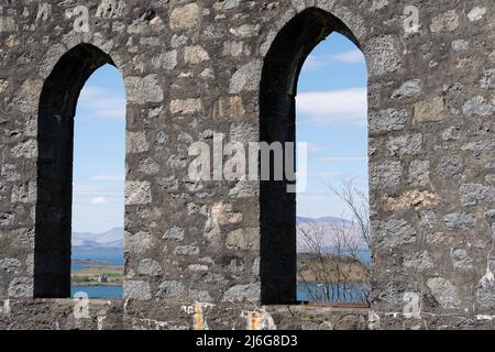 Alte Steinbögen, die das schottische Loch und die Hochlandlandschaft durch die Burgruinen umrahmen Stockfoto