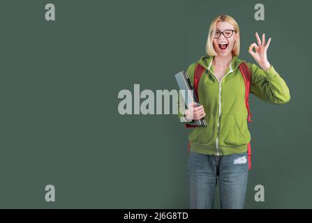 Junge Frau auf grünem Tafelhintergrund - für Textkopie Raum. Studentin, die über die Studienarbeit in der Universität nachdenkt. Stockfoto