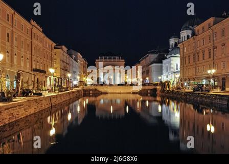 Nachtansicht des Kanals grande in Triest mit der Kirche Sant'Antonio im Hintergrund Stockfoto